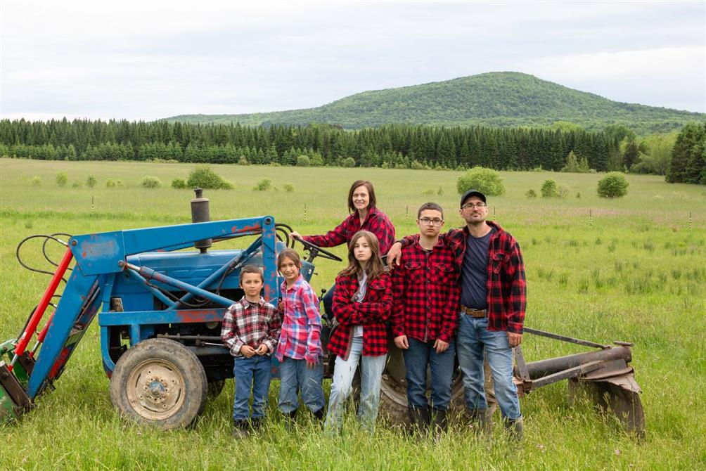 Famille de la Fromagerie Brebis de Bromont près du tracteur à la ferme